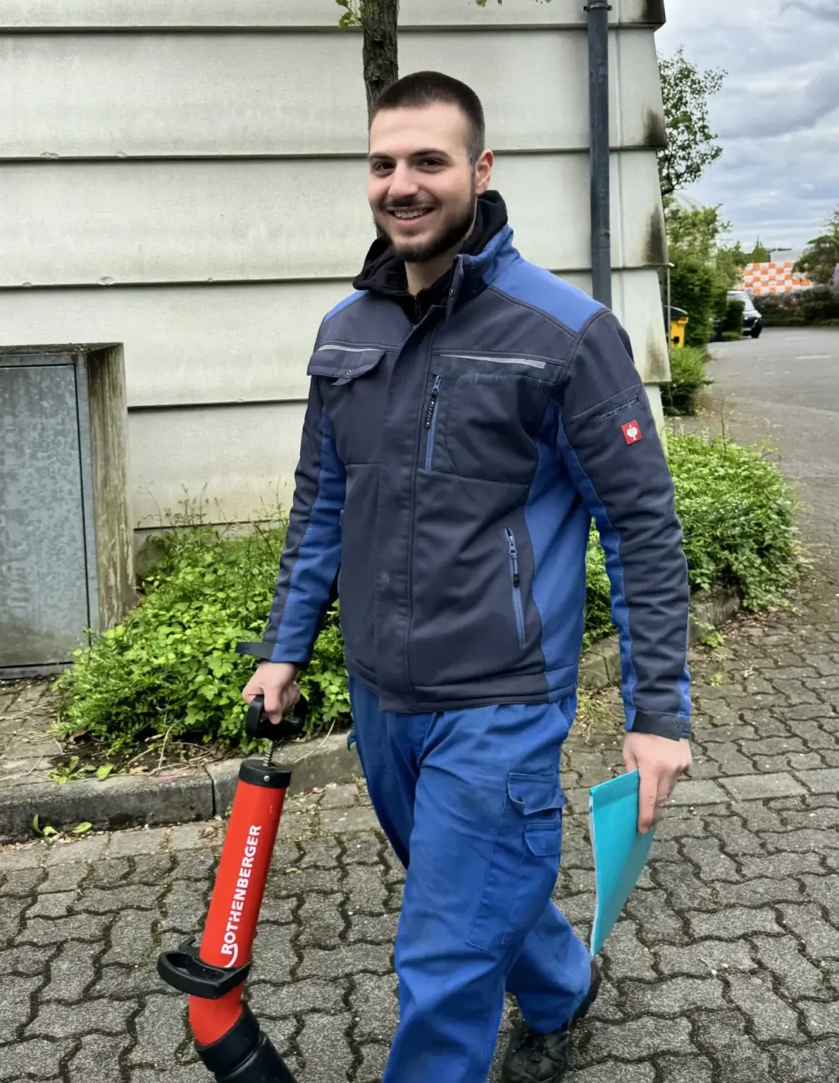 Servicetechniker mit Rohrreinigungsgerät auf dem Weg zu einem Kundeneinsatz.