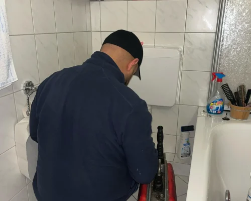 Mitarbeiter bei Absaugarbeiten einer Toilette